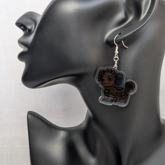 Multicolored dog Alebrije dangle earring with Mexican folk art details displayed on a black jewelry stand.