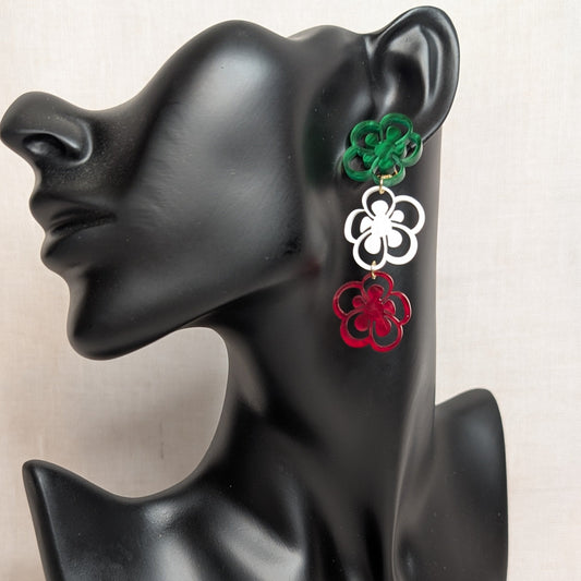 Viva Mexico three-tier floral earring in green, white, and red acrylic displayed on a black jewelry stand.