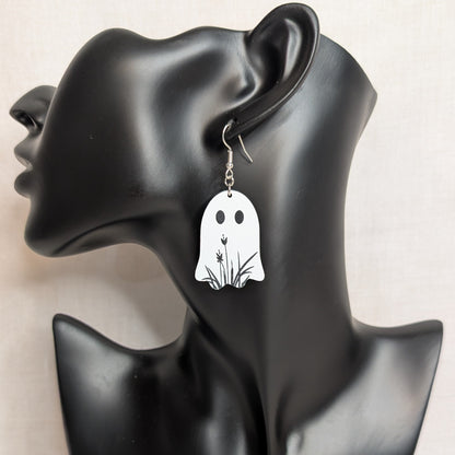 White floral ghost dangle earring displayed on a black jewelry stand, handmade Halloween accessory.