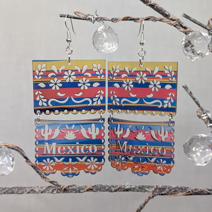 Sarape Earrings Mexico. Colorful Mexico dangle earrings with floral patterns, cactus details, and red, blue, yellow, and white accents.