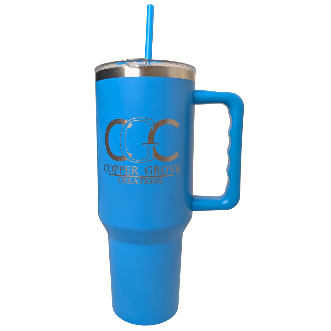 Blue Copper Grove Creations laser engraved insulated tumbler with handle and straw featuring a custom engraved logo design on a clean white background.