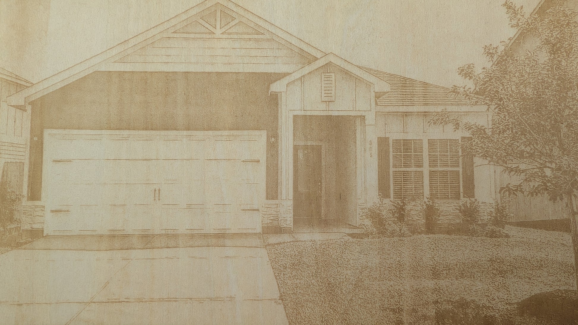 Close-up detail of a custom engraved home portrait featuring a laser engraved house illustration with intricate architectural details and precision craftsmanship.