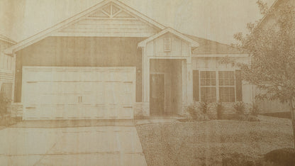 Close-up detail of a custom engraved home portrait featuring a laser engraved house illustration with intricate architectural details and precision craftsmanship.