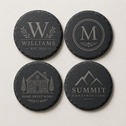 Set of four custom engraved round slate coasters featuring a family name, monogram, home design, and business logo.