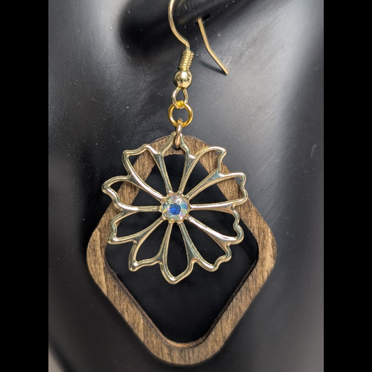 Geometric wood and metal frame dangle earring with a gold floral design and iridescent center stone.