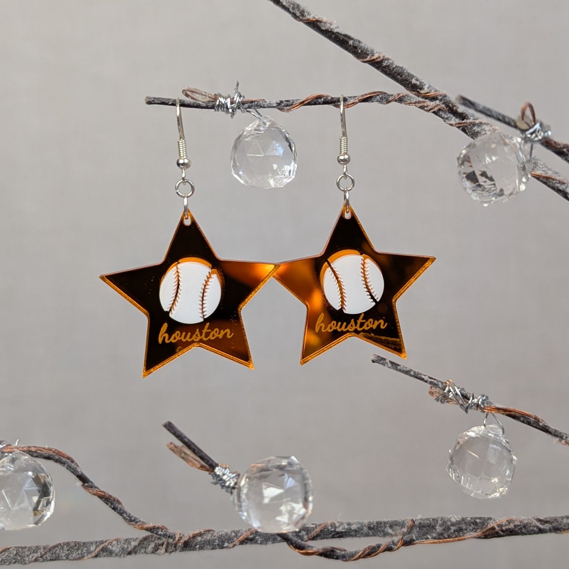 Orange Houston baseball star dangle earring with a white baseball design displayed on a black jewelry stand.