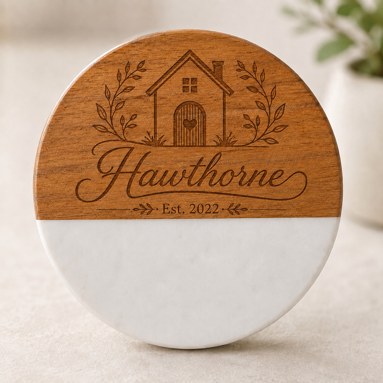 Personalized round marble and acacia wood coaster engraved with the Hawthorne family name, house design, and established date.