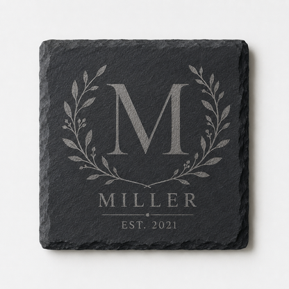 Personalized square slate coaster engraved with a Miller family monogram, botanical wreath, and established date.