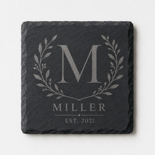 Personalized square slate coaster engraved with a Miller family monogram, botanical wreath, and established date.