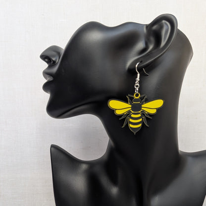 Yellow and black Sweet Buzz-Worthy Bee dangle earring displayed on a black jewelry stand.