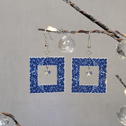 Cobalt blue Talavera square earrings with white floral patterns and iridescent crystal dangle charms.