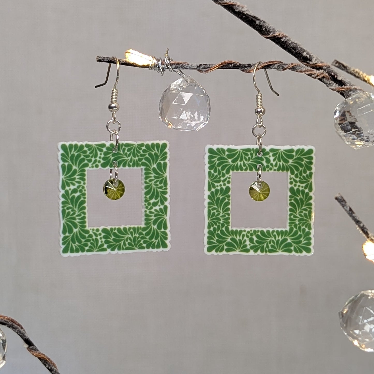 Green Talavera square earrings with white floral patterns and matching green crystal dangle charms.