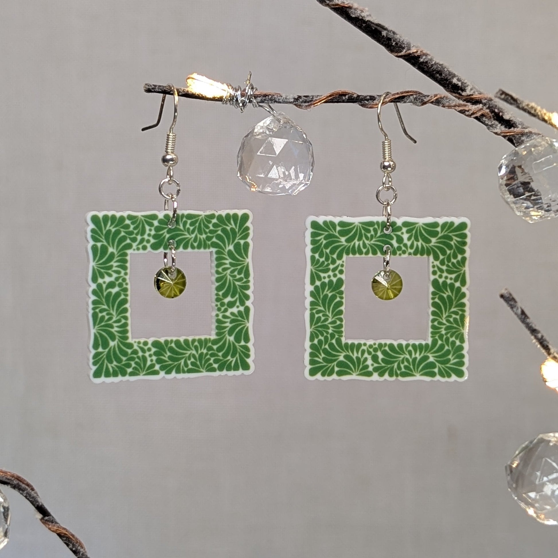 Green Talavera square earrings with white floral patterns and matching green crystal dangle charms.