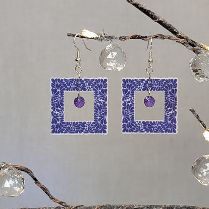 Purple Talavera square earrings with white floral patterns and matching purple crystal dangle charms.